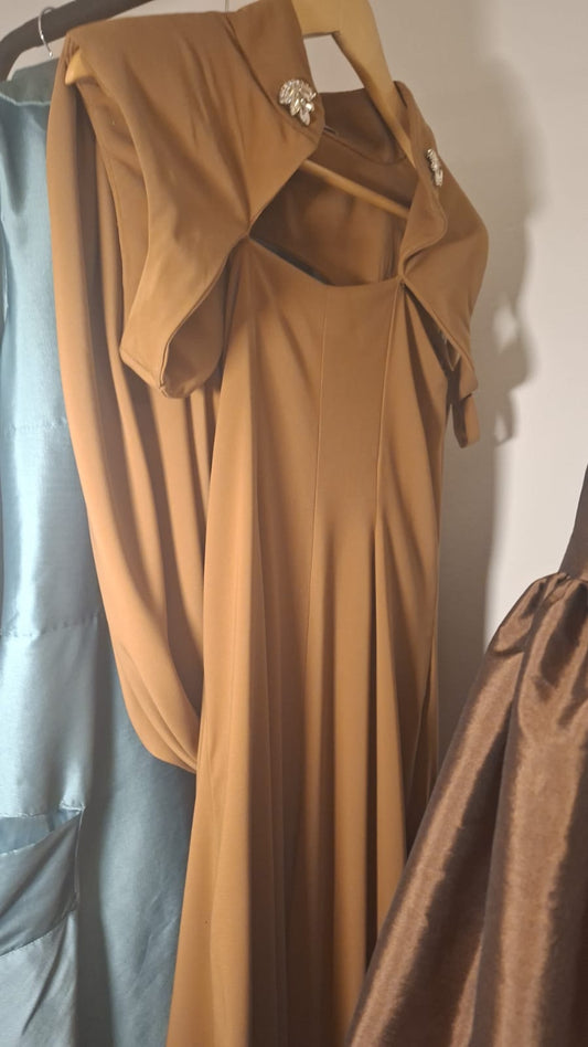 OCHRE JUMPSUIT WITH INTEGRATED CAPE AND JEWELED BROOCHES